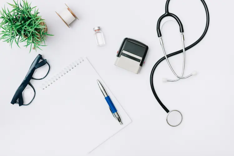 Stetoskop, czysty notatnik i okulary na białym biurku lekarza – wizualizacja planowania wydatków na prywatną opiekę medyczną w Polsce.