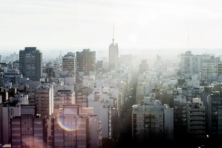 Panorama gęstej zabudowy miejskiej w świetle porannego słońca – metafora cykli rynkowych i sezonowości w małej firmie.