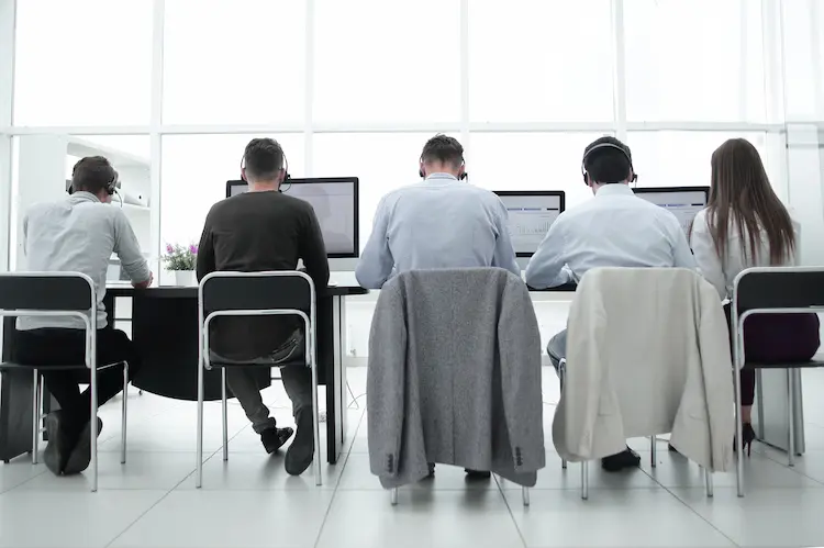 Zespół specjalistów pracujący przy komputerach w nowoczesnym biurze – analiza zagadnienia jakie podatki płaci fundacja rodzinna.