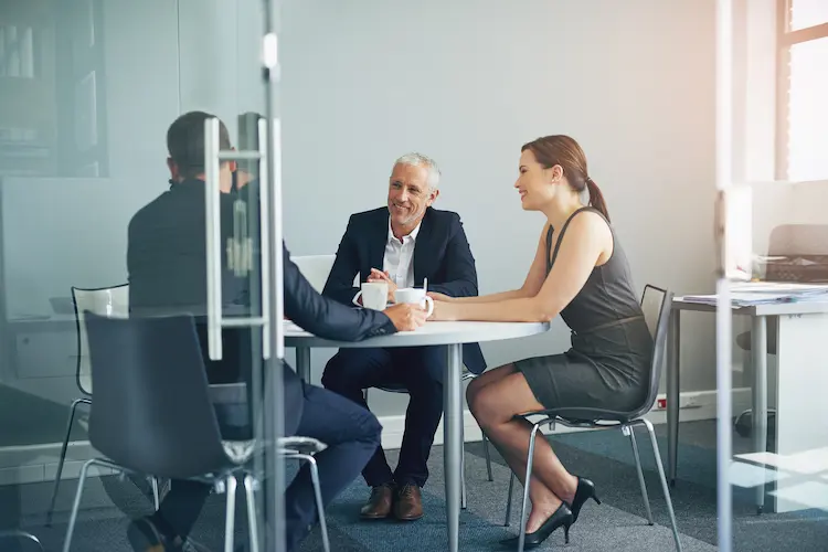 Zespół profesjonalistów podczas spotkania biznesowego przy kawie omawiający skuteczny marketing w małej i średniej firmie.