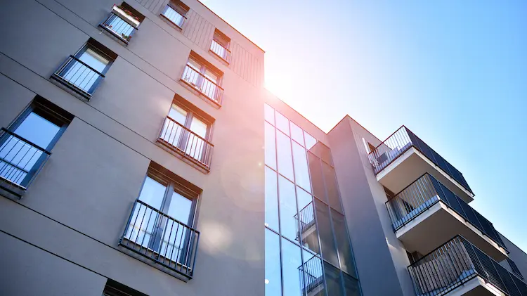 Nowoczesny apartamentowiec o wysokim standardzie na tle błękitnego nieba – rynek nieruchomości 2026.