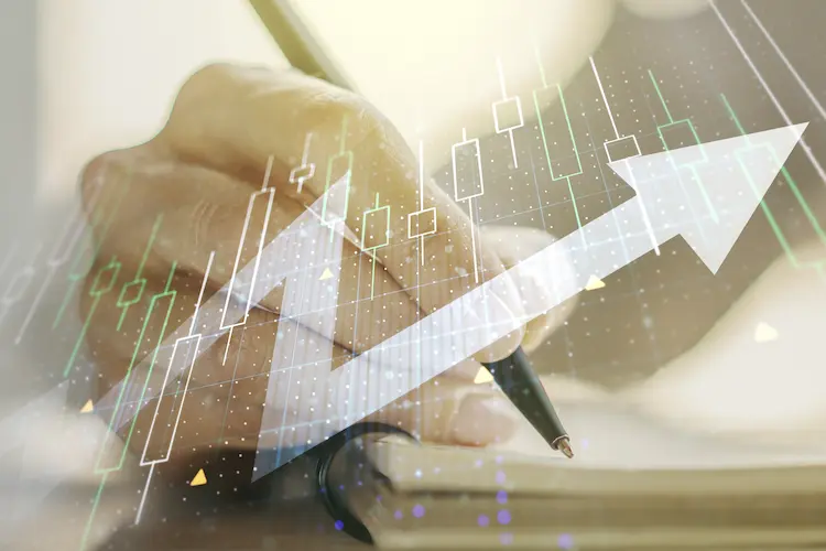 Dłoń analityka na tle wykresu giełdowego FW20 ze strzałką wzrostową – profesjonalny trading kontraktami terminowymi w 2026 roku.