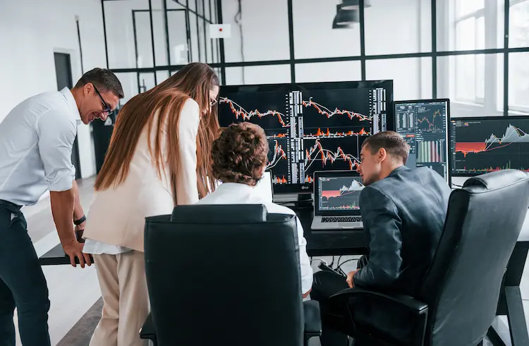 Zespół analityków analizujący wykresy giełdowe spółek Skarbu Państwa na dużych monitorach w biurze w 2026 roku.